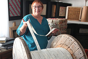 Papier und Holz sind ihr Element: Die Jockgrimer Künstlerin Silvia Mielke in ihrem Atelier mit einer Bibelrolle. Foto: VAN