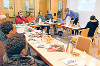 Auftakt zum geselligen Nachmittag in der Stadtmission: Claudia Starck (Zweite von rechts) gibt per Powerpoint-Präsentation eine Kurseinheit Deutsch. Foto: Benndorf