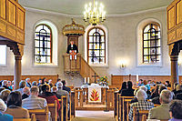 Während der Festpredigt in der Kirche in Miesau: Christian Schad auf der Kanzel zwischen den neuen Schreiter-Kunstfenstern im Altarraum. Foto: view